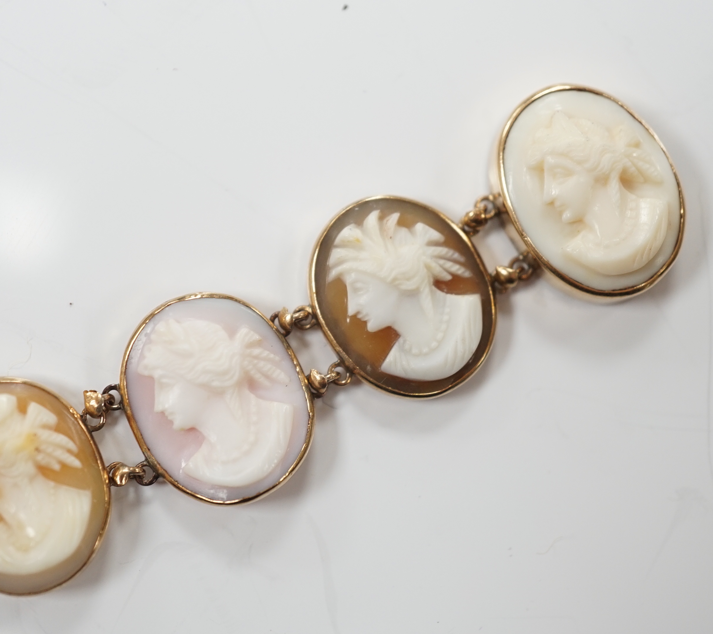 A yellow metal mounted ten stone oval cameo shell set bracelet, each carved with bust of a lady to sinister, 16cm, gross weight 13.9 grams.